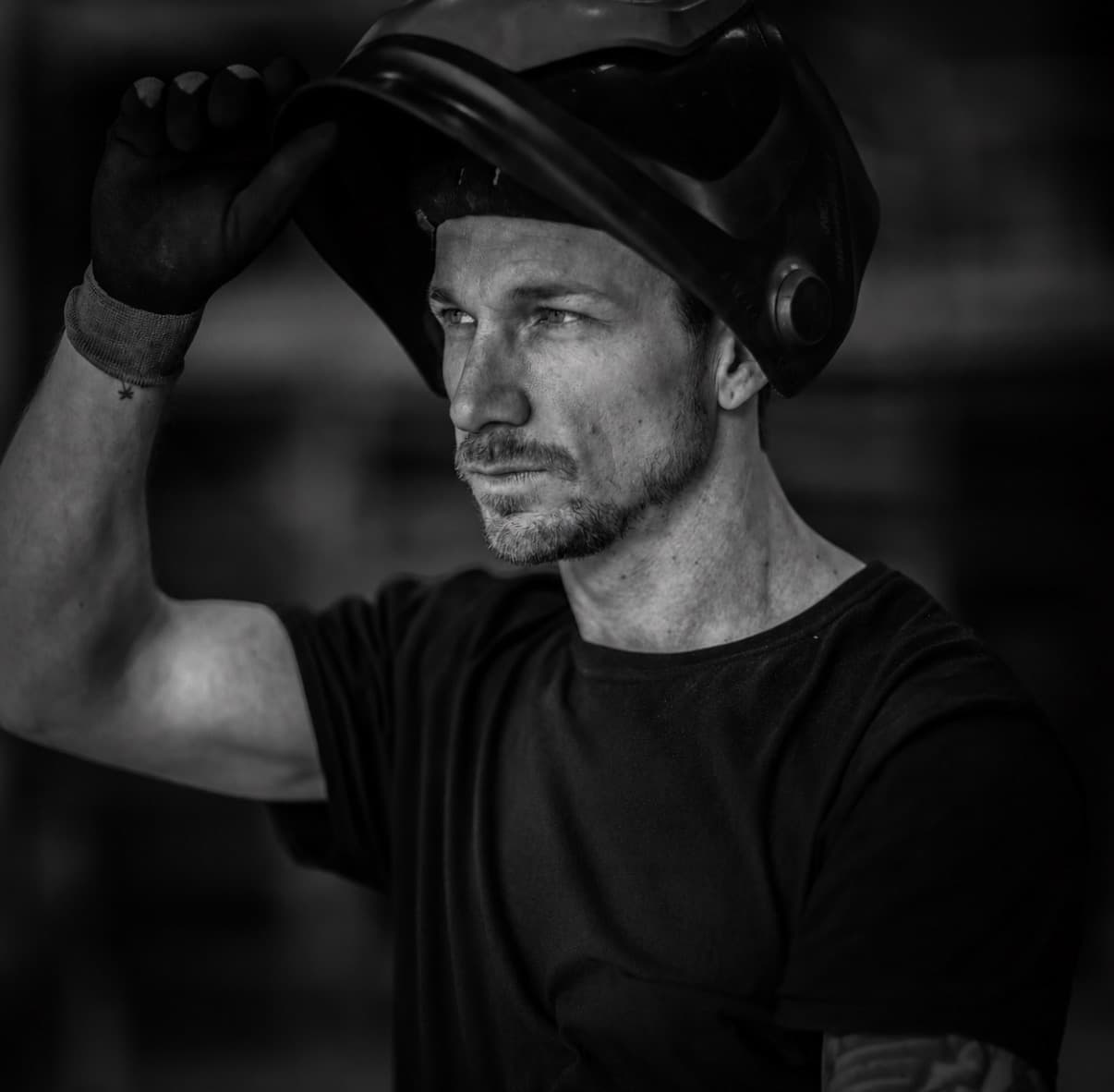 Founder of Irona of Sweden — lifting welding helmet in the workshop