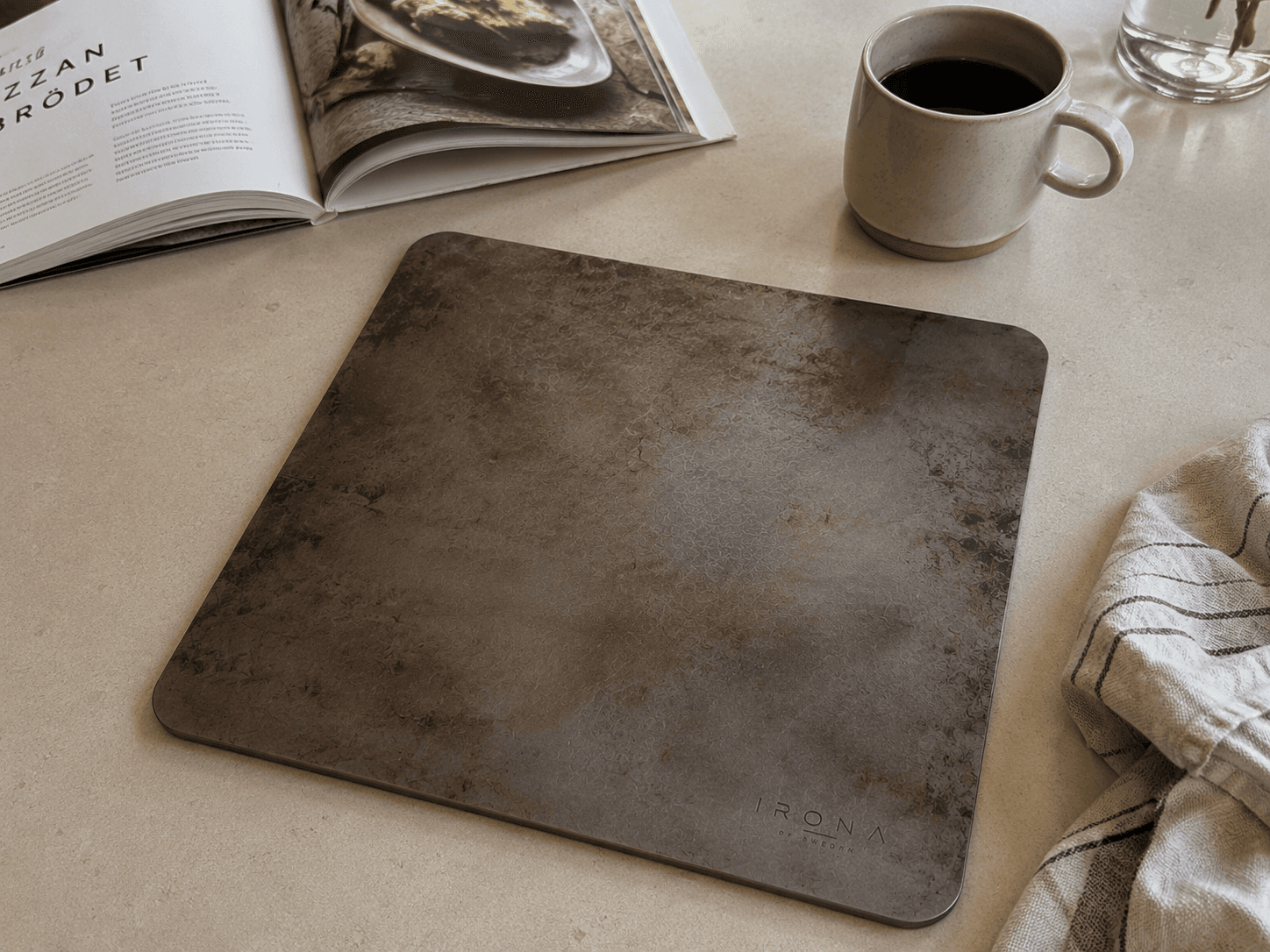 Irona 38 carbon steel baking plate styled with cookbook and coffee