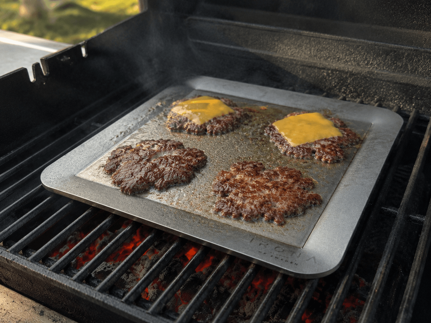 Smash burgers cooking on the Irona 38 carbon steel griddle plate