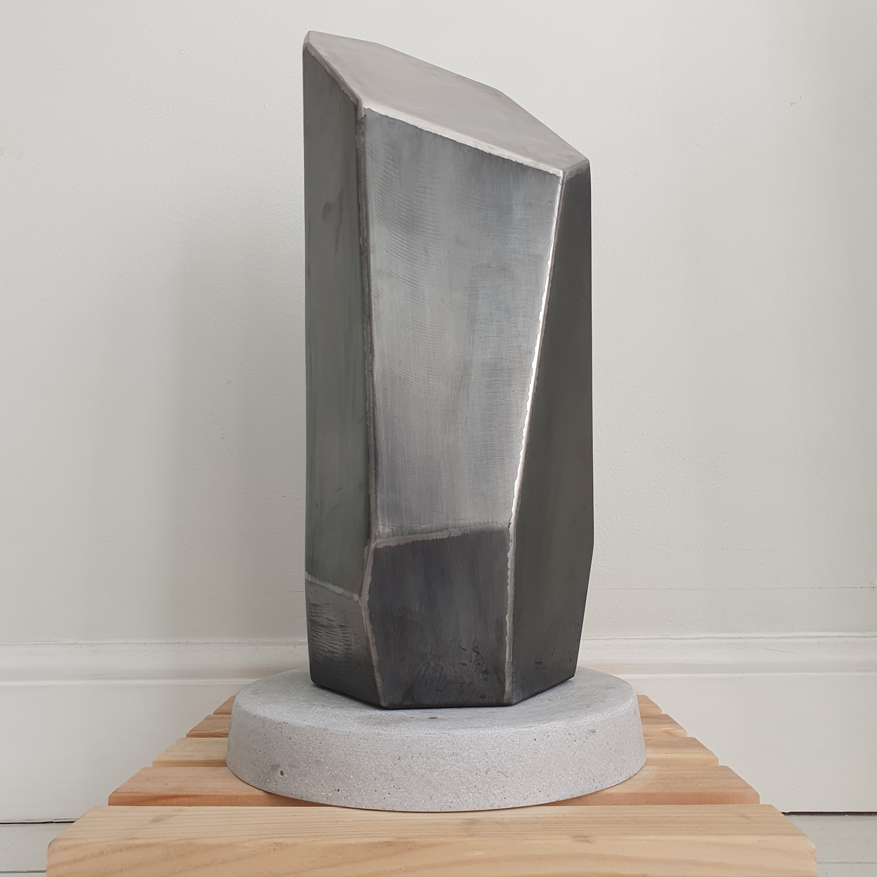 Faceted geometric mild steel sculpture on a concrete plinth — bespoke commission, Stockholm